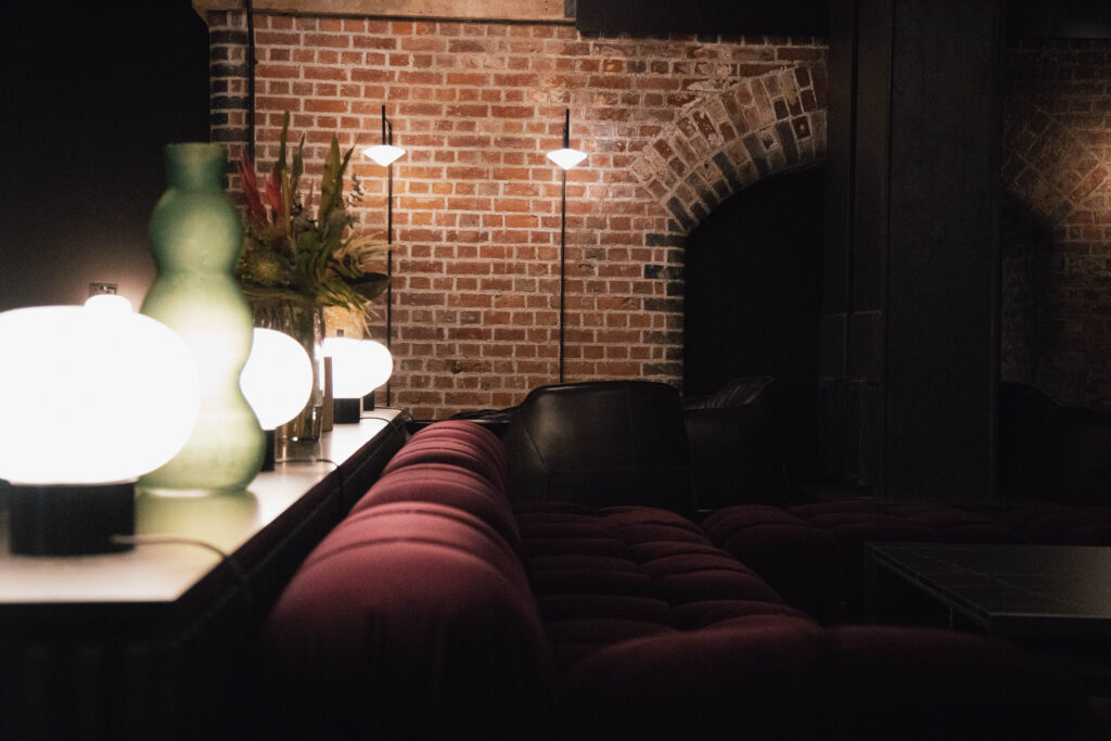 Cozy lounge with brick walls and soft lighting.