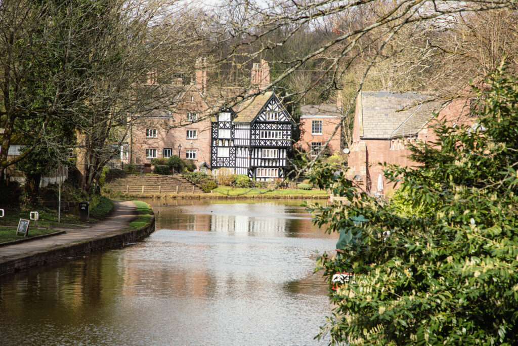 Historic building by canal on sunny day.
