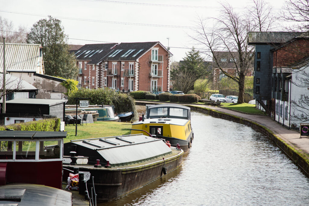 Canal with colorful boats by residential buildings.
